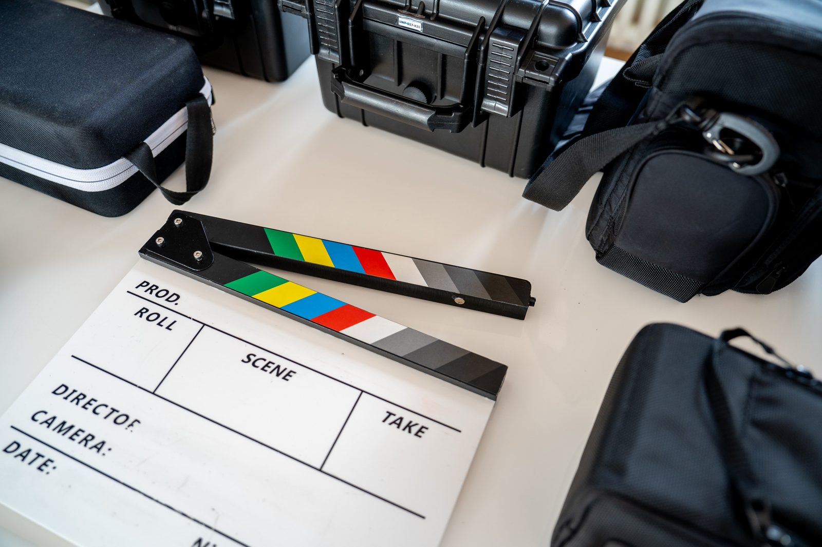 Filmklappe inmitten von Equipment-Koffern