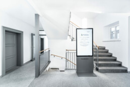 Moderner Eingangsbereich Rathaus mit digitaler Anzeigetafel und Treppenhaus, saniert von RSP Architekten