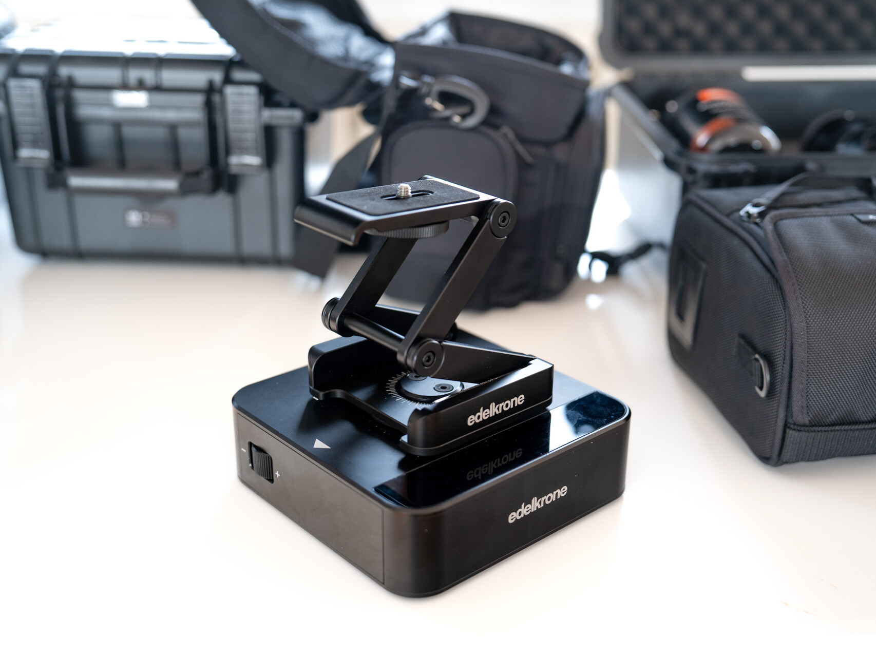 Edelkrone Slider steht auf Tisch vor Koffern und Taschen mit weiterem Equipment